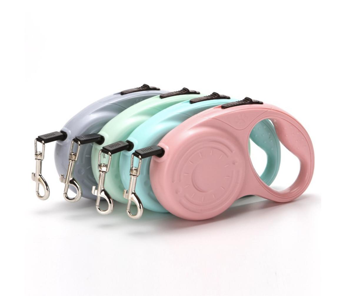 Automatic retractable dog leads in pink, teal, and grey, coiled and shown together